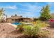 View of a backyard features a sparkling fenced pool, covered patio, and desert landscaping at 4510 W North Ln, Glendale, AZ 85302