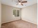 Bedroom with tan carpet, fan, and window overlooking the front yard at 4510 W North Ln, Glendale, AZ 85302