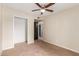 Bedroom features tan carpet, ceiling fan, and hallway access at 4510 W North Ln, Glendale, AZ 85302