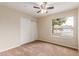 Bedroom featuring carpet, closet, fan, and window overlooking the front yard at 4510 W North Ln, Glendale, AZ 85302