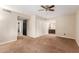 Cozy carpeted bedroom with ceiling fan and view into the adjacent bathroom at 4510 W North Ln, Glendale, AZ 85302