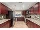 Well-appointed kitchen features stainless steel appliances, granite countertops, and mosaic tile backsplash at 4510 W North Ln, Glendale, AZ 85302