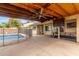 A covered patio features a ceiling fan, outdoor seating, and a view of the fenced pool at 4510 W North Ln, Glendale, AZ 85302