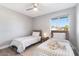Bright bedroom featuring two twin beds, a ceiling fan, and natural light from a window at 4645 E Covina St, Mesa, AZ 85205
