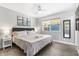 Cozy bedroom with a ceiling fan, large window, gray walls, and wood-look flooring at 4645 E Covina St, Mesa, AZ 85205