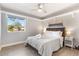 Bedroom with a ceiling fan, side tables with lamps, wood-look floors, and a large window at 4645 E Covina St, Mesa, AZ 85205
