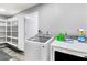 Laundry room with a front-load washer and dryer, storage cabinets, and gray walls at 4645 E Covina St, Mesa, AZ 85205
