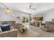 Cozy living room with a ceiling fan, sectional sofa, and access to the backyard through sliding glass doors at 4645 E Covina St, Mesa, AZ 85205