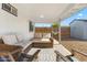 Inviting outdoor patio area with wicker seating, a colorful rug, and access to the backyard at 4645 E Covina St, Mesa, AZ 85205
