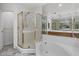 Bright bathroom with a soaking tub, glass shower, and double sink vanity with a large mirror at 5200 S Lakeshore Dr # 120, Tempe, AZ 85283