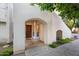 Inviting front entrance with arched entryway and a solid wood door, complemented by lush greenery at 5200 S Lakeshore Dr # 120, Tempe, AZ 85283