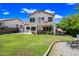 Lush backyard with a green lawn, mature trees, and a two-story home with a balcony at 5341 W Bloomfield Rd, Glendale, AZ 85304