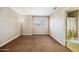 Neutral bedroom with a window with shutters, and a bathroom visible through an open door at 5341 W Bloomfield Rd, Glendale, AZ 85304