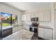 Modern kitchen featuring stainless steel appliances, granite counters, white cabinets, and lots of natural light at 5341 W Bloomfield Rd, Glendale, AZ 85304