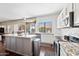 Modern kitchen with a gray island, stainless appliances, white cabinets, and dark wood flooring at 5341 W Bloomfield Rd, Glendale, AZ 85304