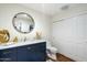Stylish bathroom featuring a blue vanity, granite counters, and a modern round mirror at 5630 E Peak View Rd, Cave Creek, AZ 85331