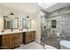 Bathroom featuring double vanities, a skylight, and a walk-in shower with decorative tiles at 5630 E Peak View Rd, Cave Creek, AZ 85331