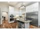 A kitchen with white cabinets, stainless steel appliances, hardwood floors, and an eat-in island at 5630 E Peak View Rd, Cave Creek, AZ 85331