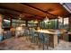 An outdoor kitchen with stainless steel appliances, a brick fireplace, and bar seating at 5630 E Peak View Rd, Cave Creek, AZ 85331