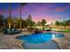 A sparkling pool with waterfall feature and poolside lounge area surrounded by lush landscaping at 5630 E Peak View Rd, Cave Creek, AZ 85331