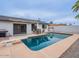 This backyard features a pool, grill, patio seating area, desert landscaping and privacy wall at 5817 S Siesta Ln, Tempe, AZ 85283