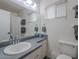 Bathroom with a sink, toilet, window, and plenty of counter space and storage at 5817 S Siesta Ln, Tempe, AZ 85283