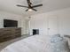 Bright bedroom featuring a ceiling fan, TV, and dresser for ample storage space at 5817 S Siesta Ln, Tempe, AZ 85283