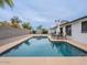 This backyard features a pool, grill, patio seating area, desert landscaping and privacy wall at 5817 S Siesta Ln, Tempe, AZ 85283