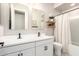 Modern bathroom featuring double sinks, a white vanity, and a bathtub with a shower at 6550 S 24Th Pl, Phoenix, AZ 85042