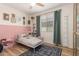 Stylishly decorated bedroom with a pink accent wall, and a decorative white metal bed frame at 6550 S 24Th Pl, Phoenix, AZ 85042