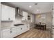 Elegant kitchen with white cabinets, stainless steel hood, and a dining area, creating an inviting space at 6550 S 24Th Pl, Phoenix, AZ 85042