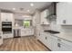 Bright kitchen with white cabinets, stainless steel appliances, and wood-look tile flooring, perfect for modern living at 6550 S 24Th Pl, Phoenix, AZ 85042
