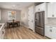 Bright kitchen with stainless steel refrigerator, white cabinetry, and cozy dining area, perfect for Gathering gatherings at 6550 S 24Th Pl, Phoenix, AZ 85042