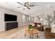 Spacious living room with hardwood floors, ceiling fan, and comfortable leather sofas at 6550 S 24Th Pl, Phoenix, AZ 85042