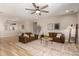 Open-concept living room with hardwood floors, ceiling fan, and comfortable leather sofas at 6550 S 24Th Pl, Phoenix, AZ 85042