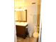 Well-lit bathroom featuring a wooden vanity, mirror, toilet, and tile flooring at 7120 E Wilshire Dr # 10, Scottsdale, AZ 85257