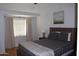 Comfortable bedroom with a wood-toned bedframe, plush bedding, and a window dressed with neutral curtains at 7120 E Wilshire Dr # 10, Scottsdale, AZ 85257
