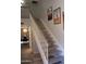 A carpeted staircase with white railings leads to the upper level, complemented by desert artwork on the wall at 7120 E Wilshire Dr # 10, Scottsdale, AZ 85257