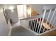 A well-lit staircase with white railings, views of the living spaces, and stylish decor creates a welcoming ambiance at 7120 E Wilshire Dr # 10, Scottsdale, AZ 85257