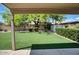 Serene backyard oasis with lush artificial grass, mature landscaping, storage shed, and covered patio at 7456 W Via Montoya Dr, Glendale, AZ 85310