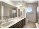 Bright bathroom with double sinks, large mirror, and a unique round window offering natural light at 7625 W Dreyfus Dr, Peoria, AZ 85381