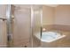 Spa-like bathroom features glass-enclosed shower and a luxurious whirlpool tub for relaxation and comfort at 7625 W Dreyfus Dr, Peoria, AZ 85381