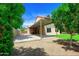 Home exterior featuring a covered parking area, lush landscaping, and a well-maintained yard at 7625 W Dreyfus Dr, Peoria, AZ 85381