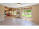 Bright living room with tile flooring, large windows overlooking the landscaped backyard, and kitchen view at 7625 W Dreyfus Dr, Peoria, AZ 85381