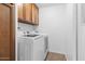 Functional laundry room with front load washer and dryer and storage cabinets at 842 E Village Circle N Dr, Phoenix, AZ 85022