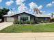 Inviting single-story home featuring a lush green lawn, desert plants, and a garage, all under a sunny sky at 8632 E Thornwood Dr, Scottsdale, AZ 85251