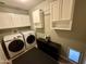 Laundry room features modern washer and dryer units, overhead cabinets and modern paint at 8632 E Thornwood Dr, Scottsdale, AZ 85251