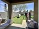 Private, shaded backyard featuring artificial grass, lounge furniture, hammock, and block fence at 9825 W Trumbull Rd, Tolleson, AZ 85353