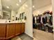 Clean bathroom with dual sinks, spacious vanity, large mirror, and an open walk-in closet at 9825 W Trumbull Rd, Tolleson, AZ 85353