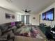 Spacious living room with neutral colors, ceiling fan, large-screen TV, and access to the backyard at 9825 W Trumbull Rd, Tolleson, AZ 85353
